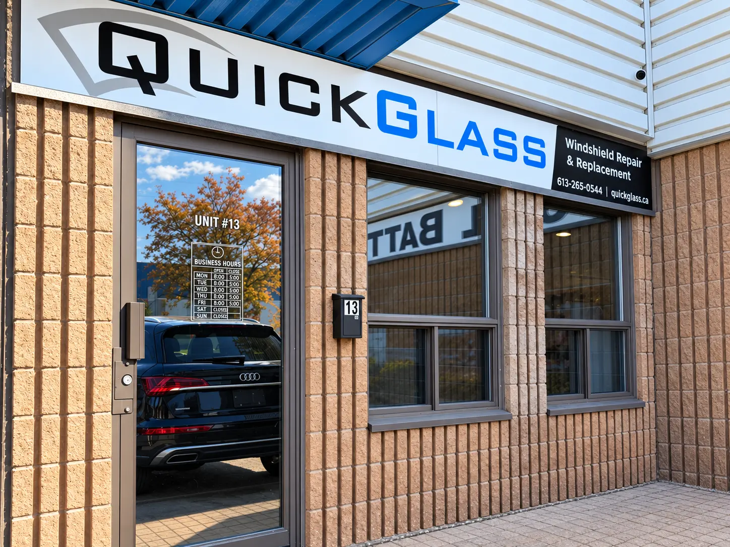 QuickGlass storefront with a black Audi reflected in the window