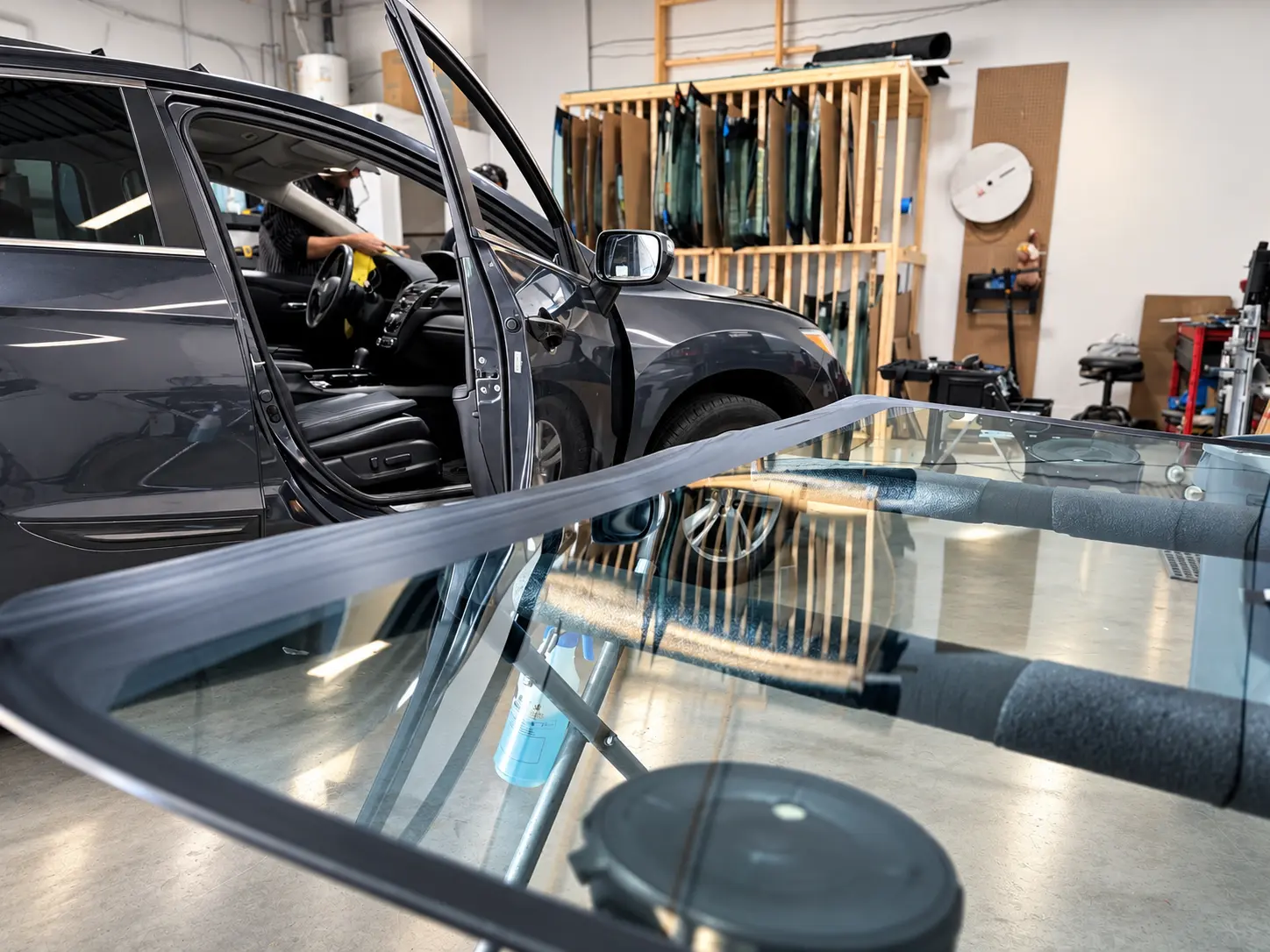 Technician performing a precision windshield replacement in the QuickGlass workshop
